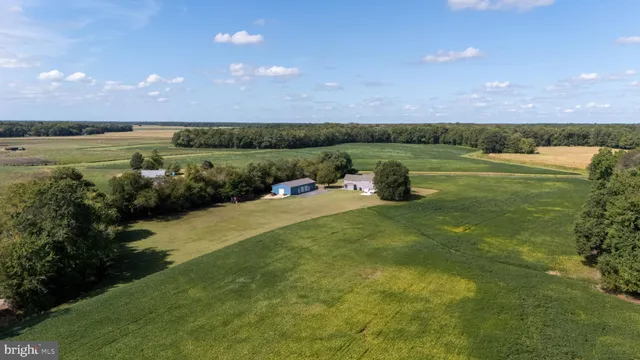 a kitchen with stainless steel appliances kitchen island granite countertop a stove top oven a sink a dining table and chairs with wooden floor