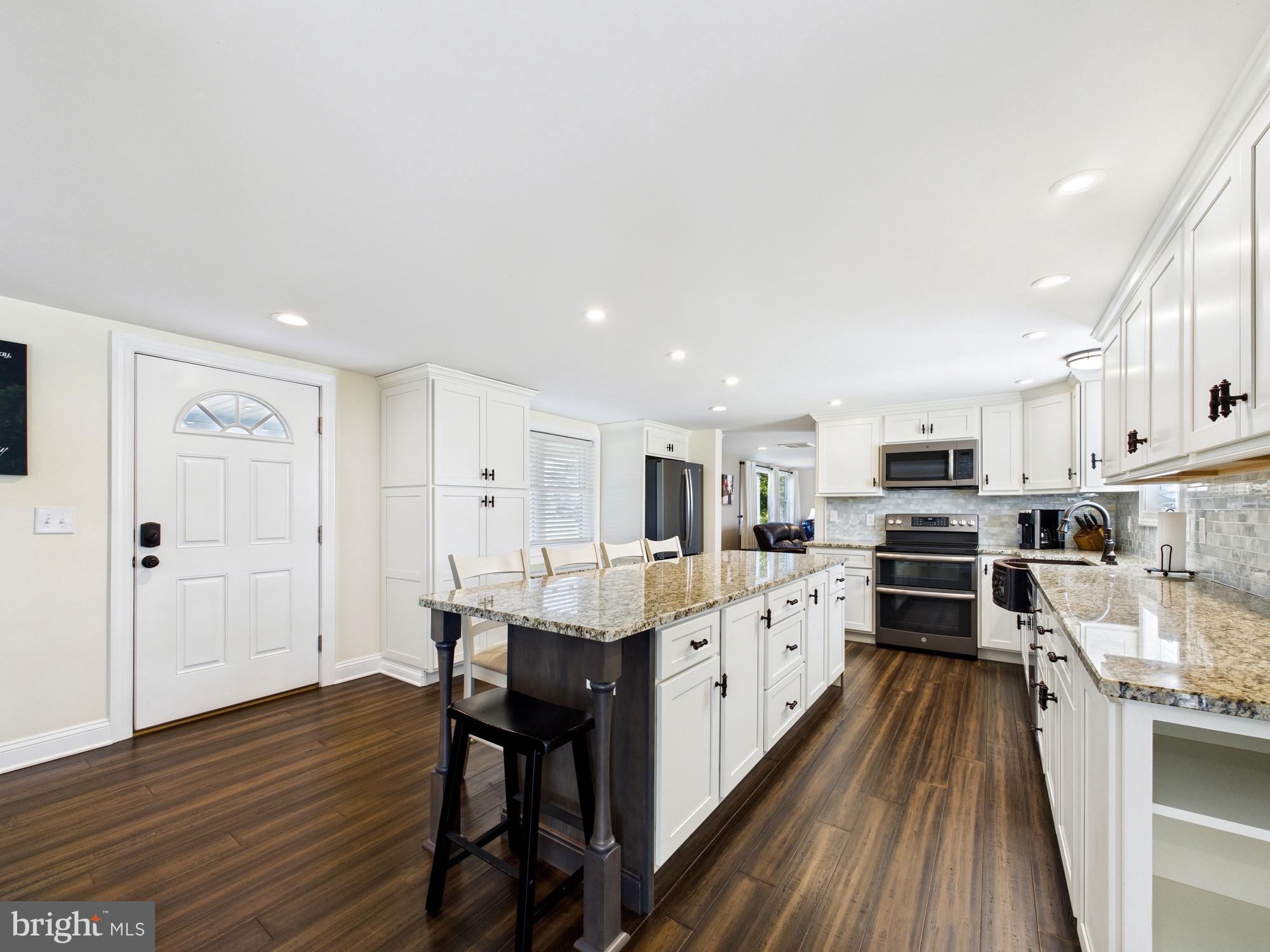 15551 Wharton Road Goldsboro, MD 21636 - Photo 5 of 80 a kitchen with stainless steel appliances kitchen island granite countertop a stove top oven a sink a dining table and chairs with wooden floor