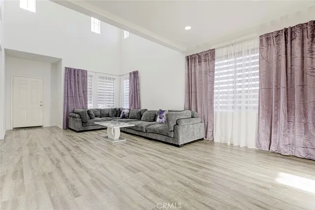 a view of a livingroom with wooden floor and stairs