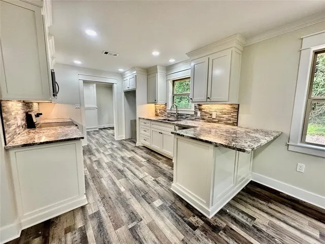 a kitchen with granite countertop a sink stove and refrigerator