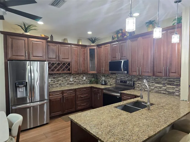 a kitchen with kitchen island granite countertop a sink stove and refrigerator