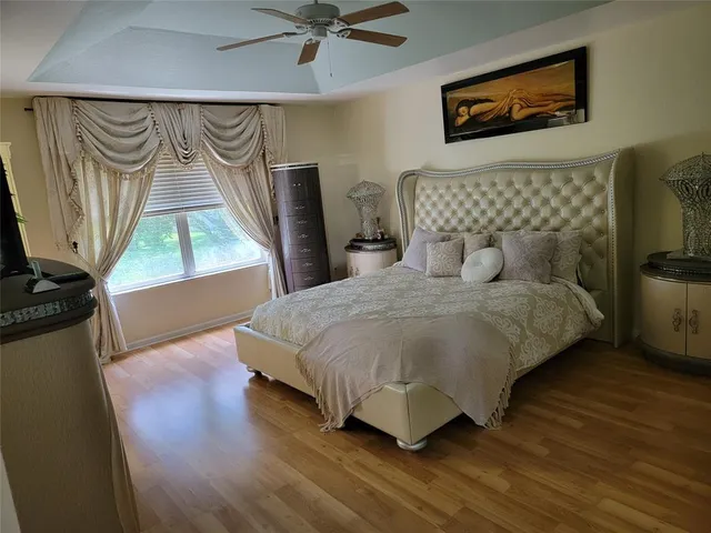 a bedroom with a bed and a flat tv screen on dresser