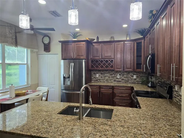 a kitchen with stainless steel appliances granite countertop a sink stove and refrigerator
