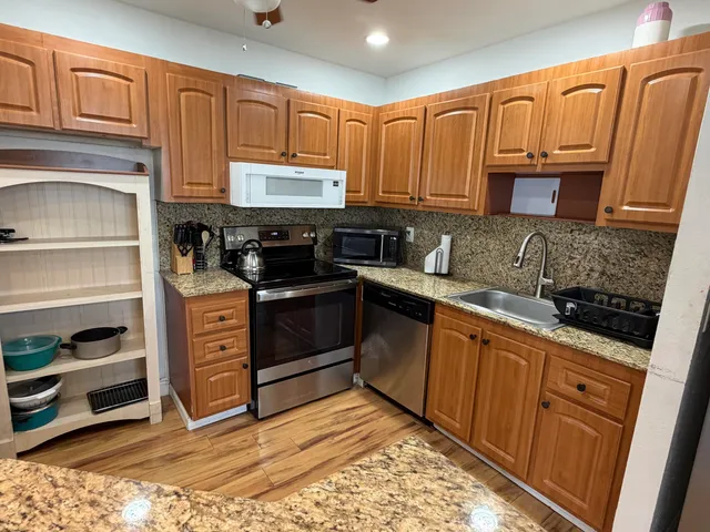 a kitchen with stainless steel appliances granite countertop a stove sink and cabinets