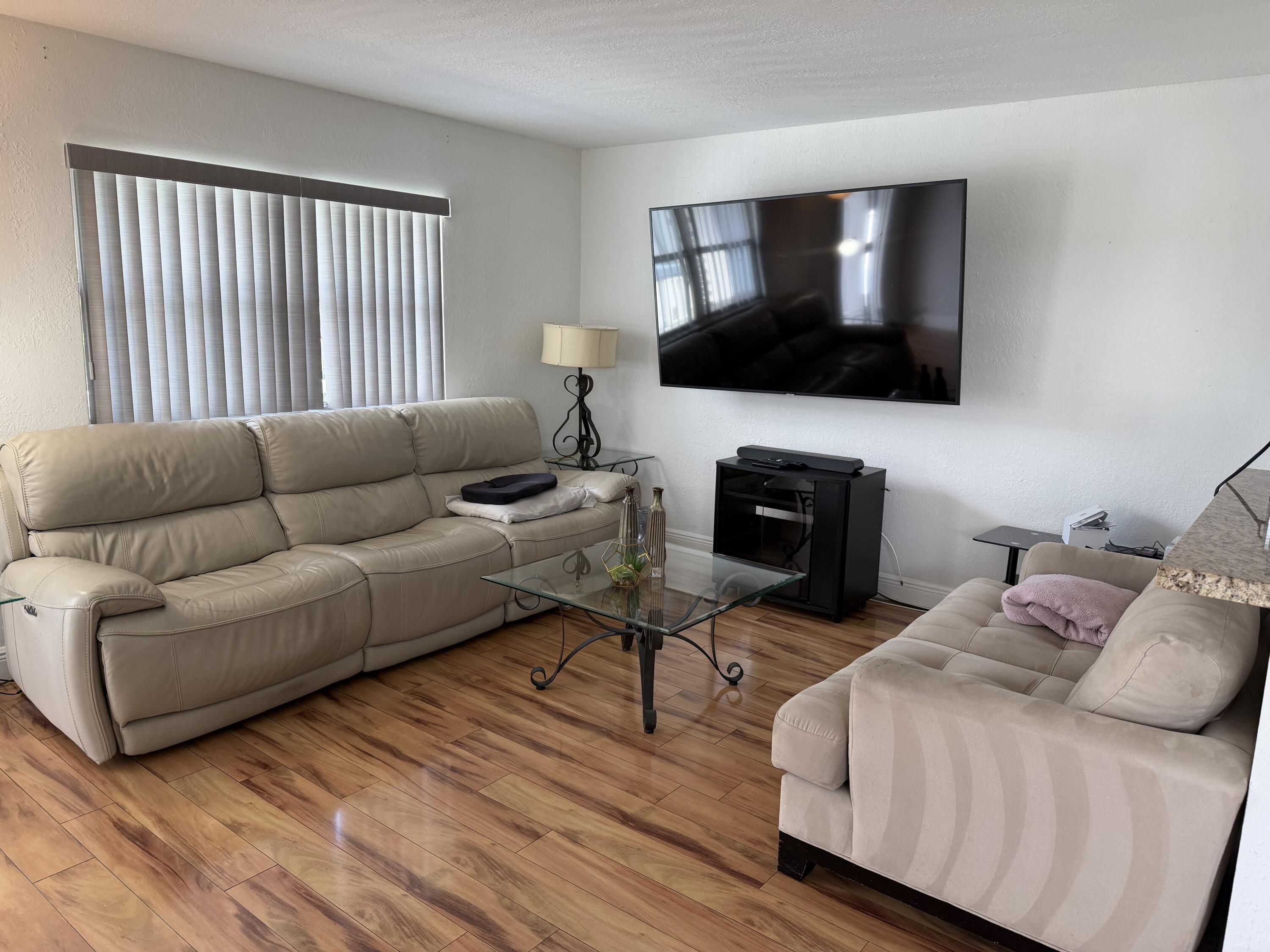 335 Tuscany Lane, Unit 335 Delray Beach, FL 33446 - Photo 6 of 15 a living room with furniture and a flat screen tv