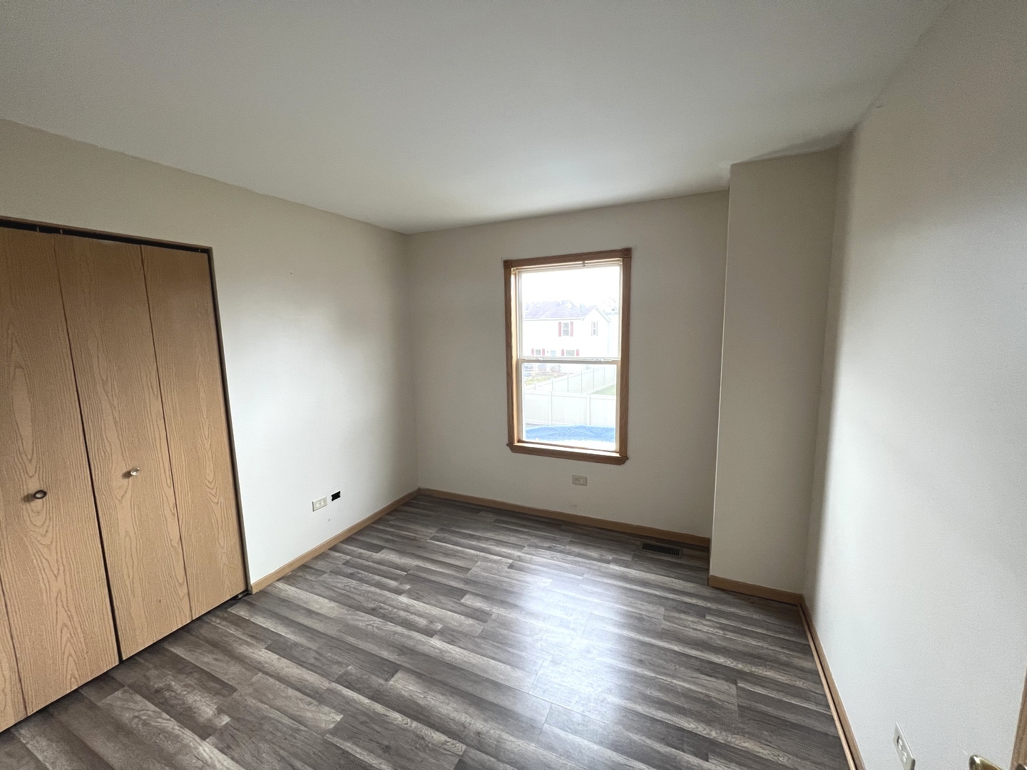 1301 Brookfield Drive Plainfield, IL 60586 - Photo 13 of 25 a view of an empty room with wooden floor and a window