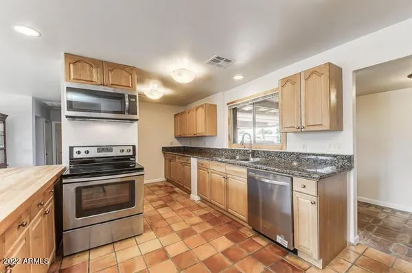 a kitchen with stainless steel appliances granite countertop a stove and a sink