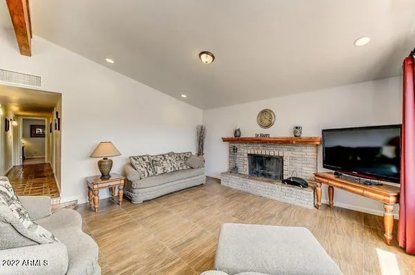 a living room with furniture a fireplace and a flat screen tv