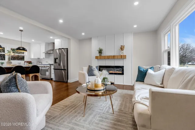 a living room with furniture kitchen view and a refrigerator
