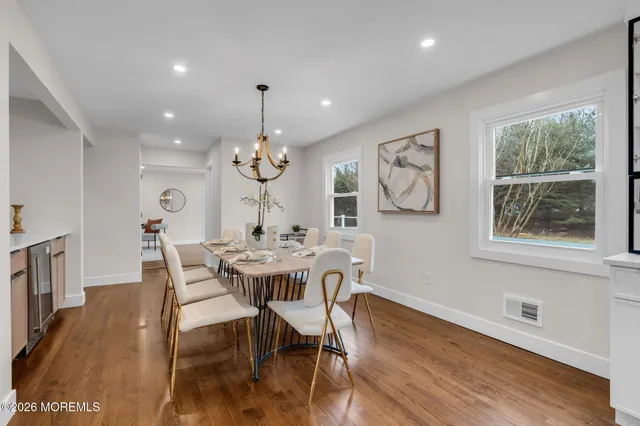 a view of a dining room with furniture a chandelier and wooden floor