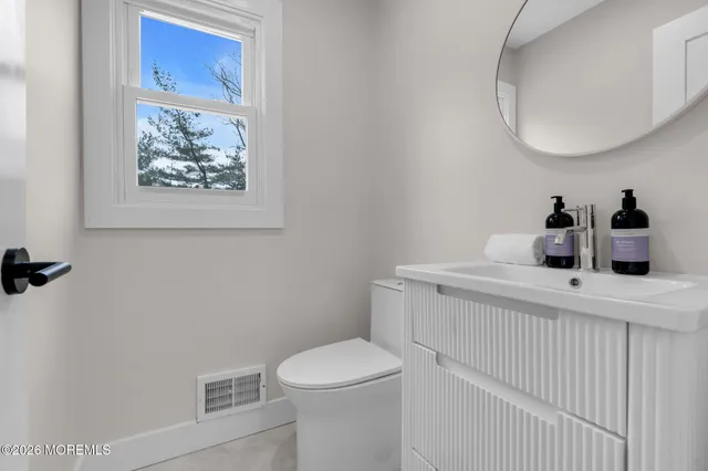 a bathroom with a toilet a sink and mirror