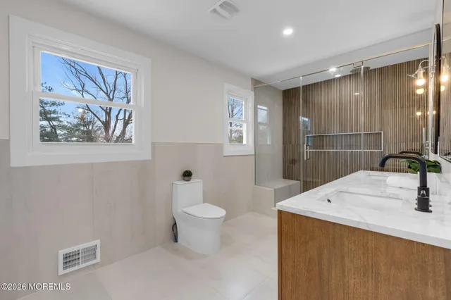 a bathroom with a sink a toilet and shower
