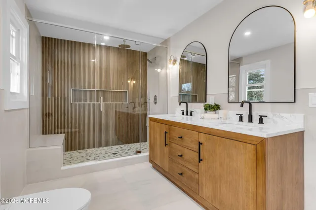 a bathroom with a double vanity sink toilet and shower