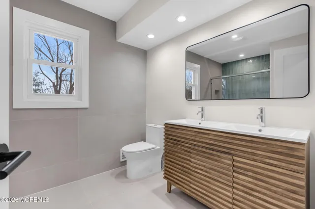 a bathroom with a toilet a sink and mirror