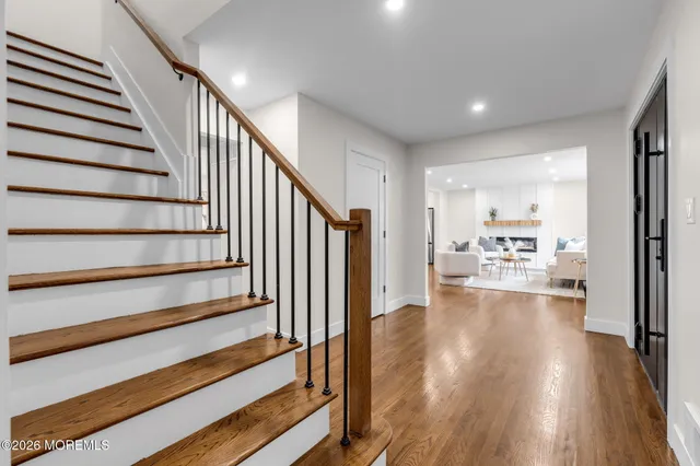 a view of a living room with wooden floor and a kitchen view