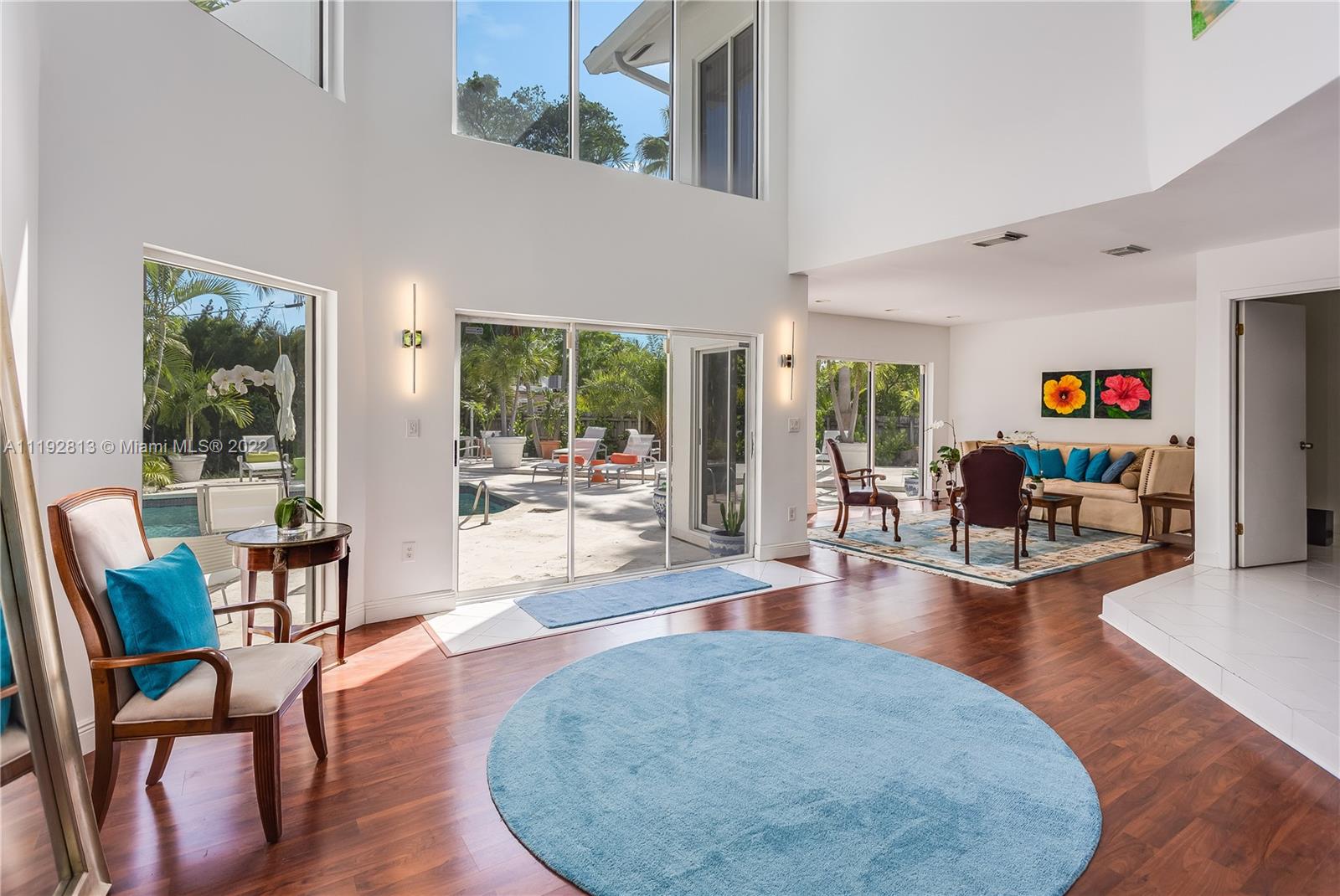6180 Pine Tree Drive Miami Beach, FL 33140 - Photo 17 of 32 a living room with furniture and a dining table with wooden floor