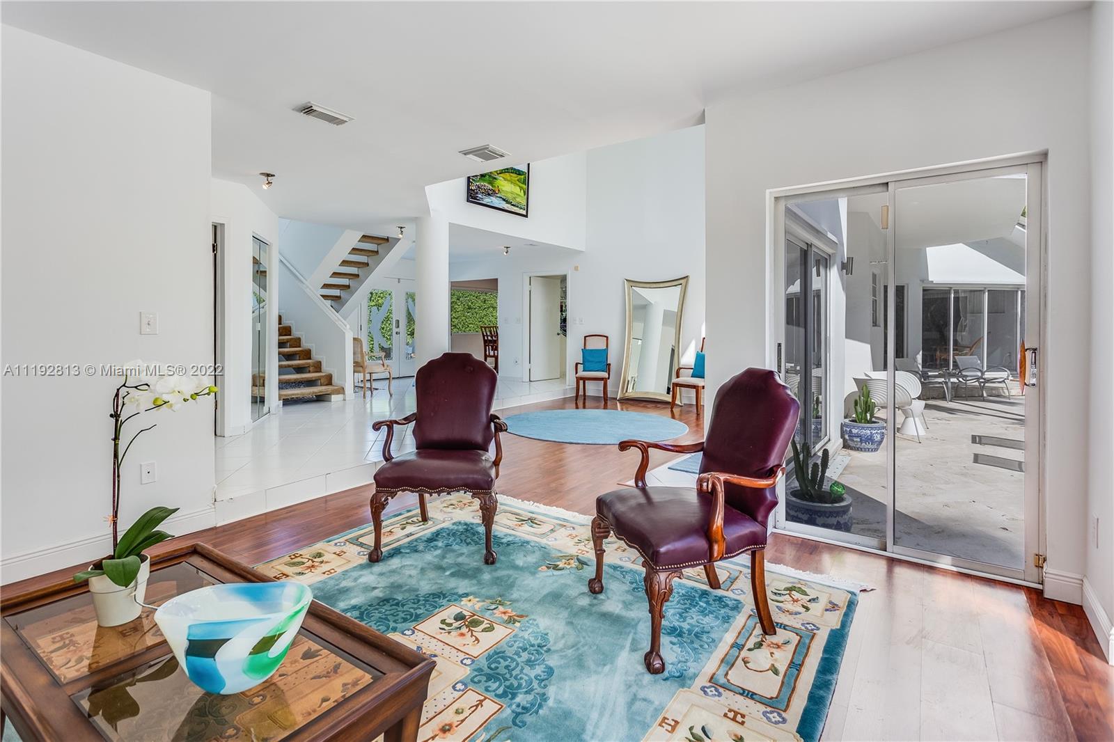 6180 Pine Tree Drive Miami Beach, FL 33140 - Photo 18 of 32 a living room with furniture and a chandelier