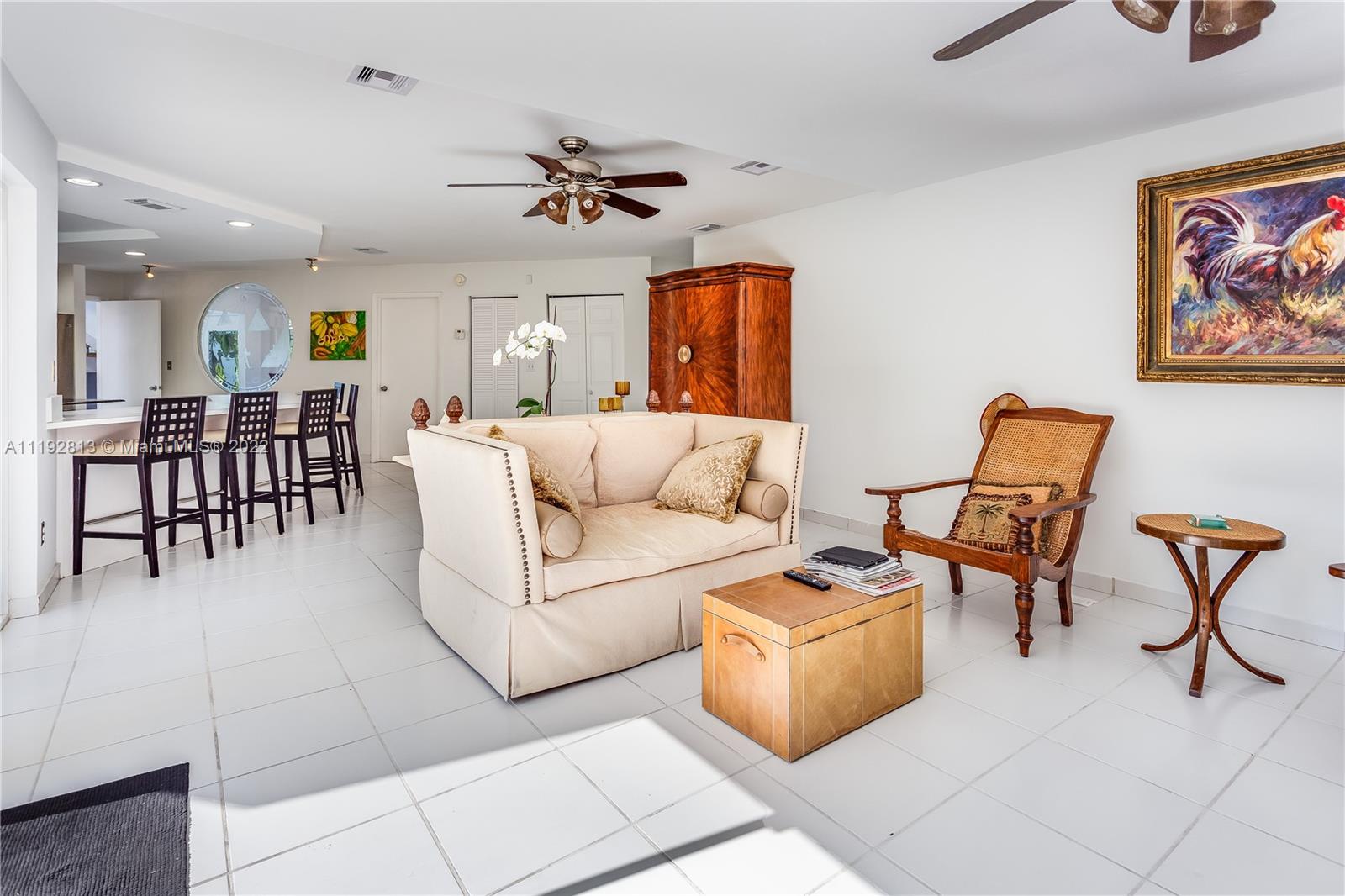 6180 Pine Tree Drive Miami Beach, FL 33140 - Photo 21 of 32 a living room with furniture and a dining table with wooden floor