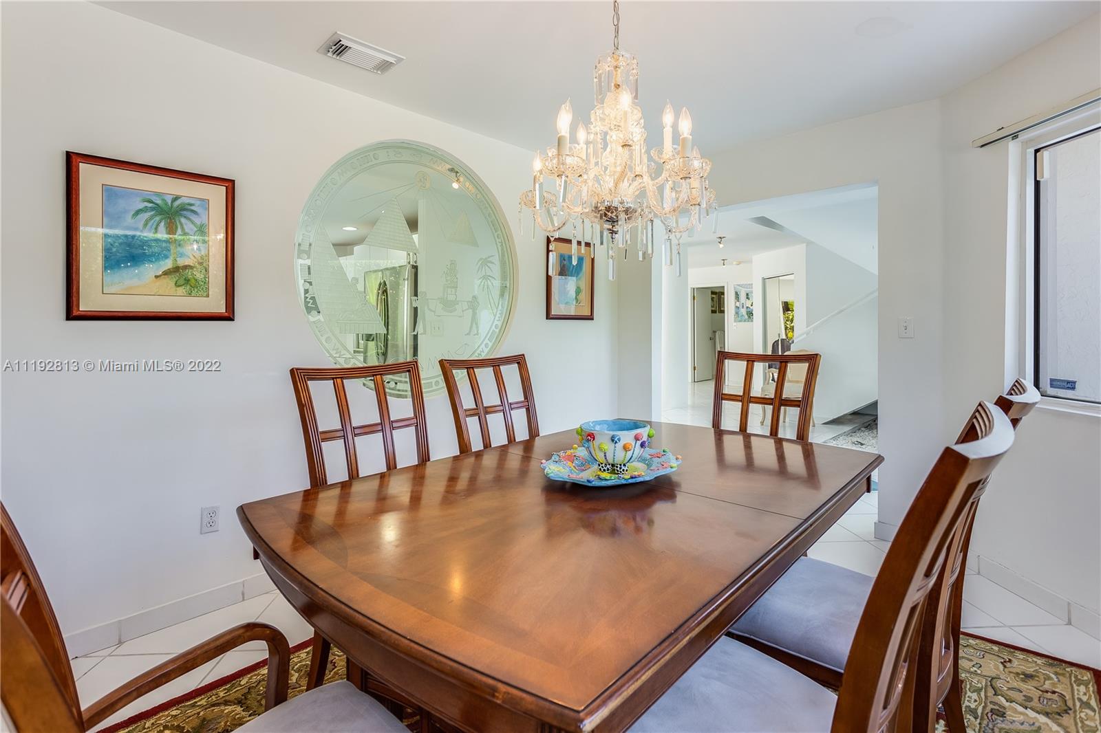 6180 Pine Tree Drive Miami Beach, FL 33140 - Photo 22 of 32 a view of a dining room with furniture and chandelier