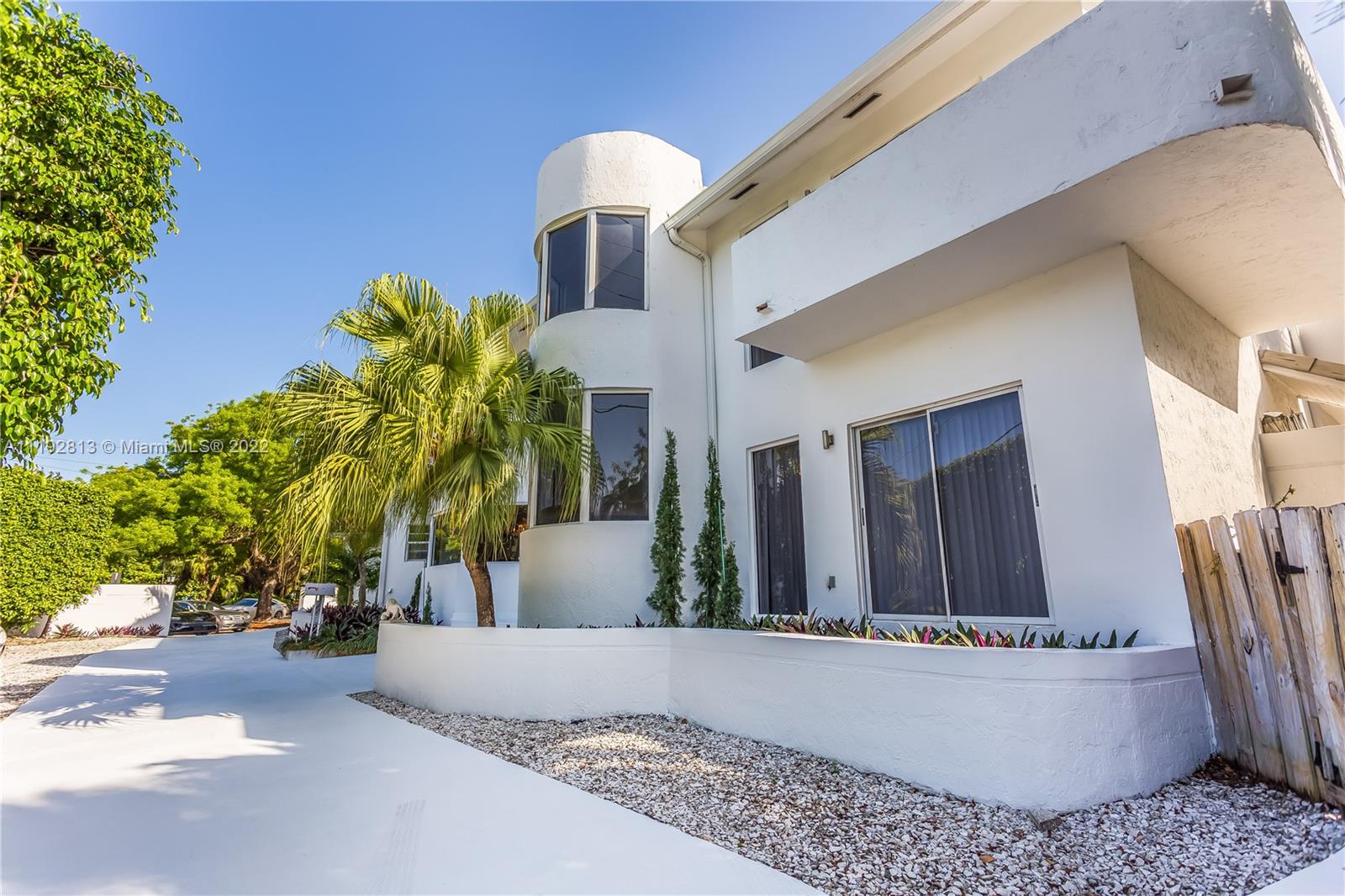 6180 Pine Tree Drive Miami Beach, FL 33140 - Photo 5 of 32 a view of a house with potted plants and a large tree