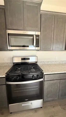 a kitchen with granite countertop a stove and a refrigerator