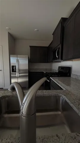 a kitchen with granite countertop stainless steel appliances and wooden cabinets
