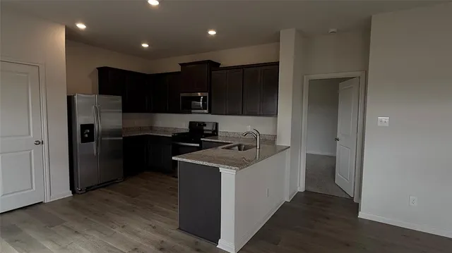a view of kitchen with refrigerator and microwave