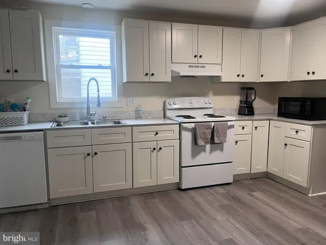 a kitchen with white cabinets sink and white appliances