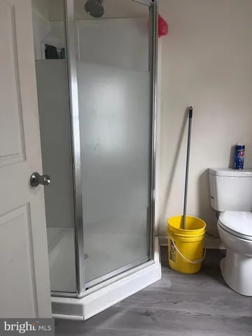 a bathroom with a stainless steel toilet and a shower