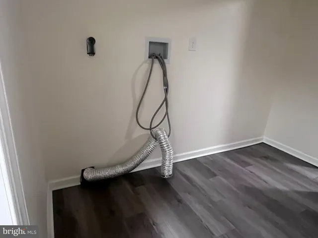 a room with gym equipment and wooden floor