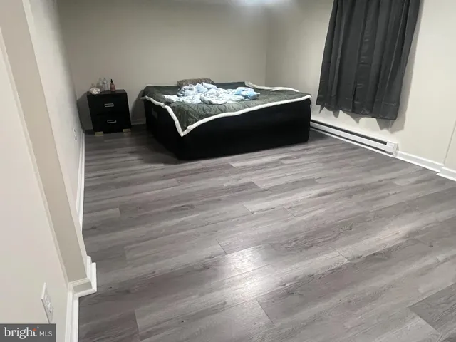 a room with bed and wooden floor