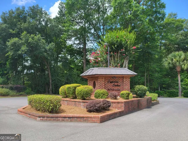 a view of a house with a yard and large trees