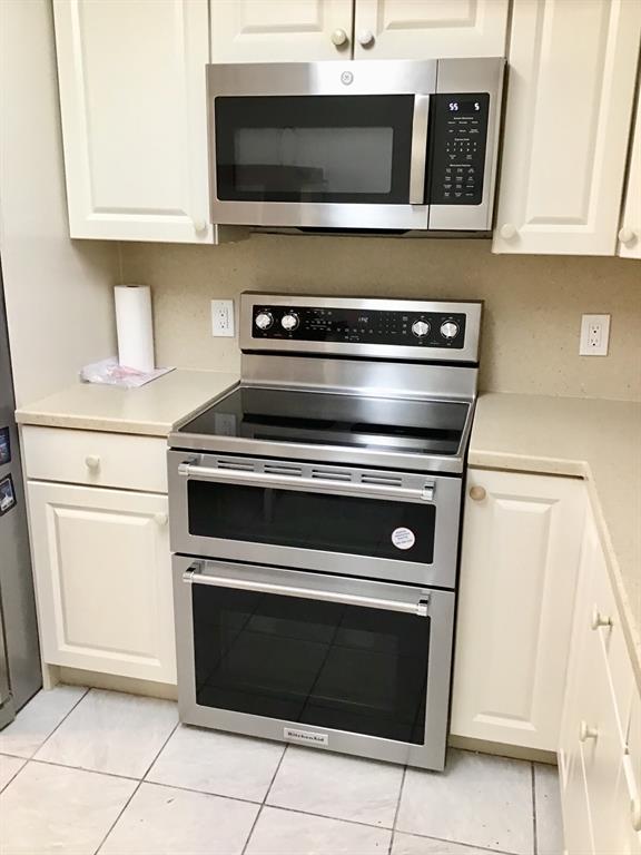 1004 Newcastle A, Unit 1004 Boca Raton, FL 33434 - Photo 11 of 39 a stove top oven sitting inside of a kitchen