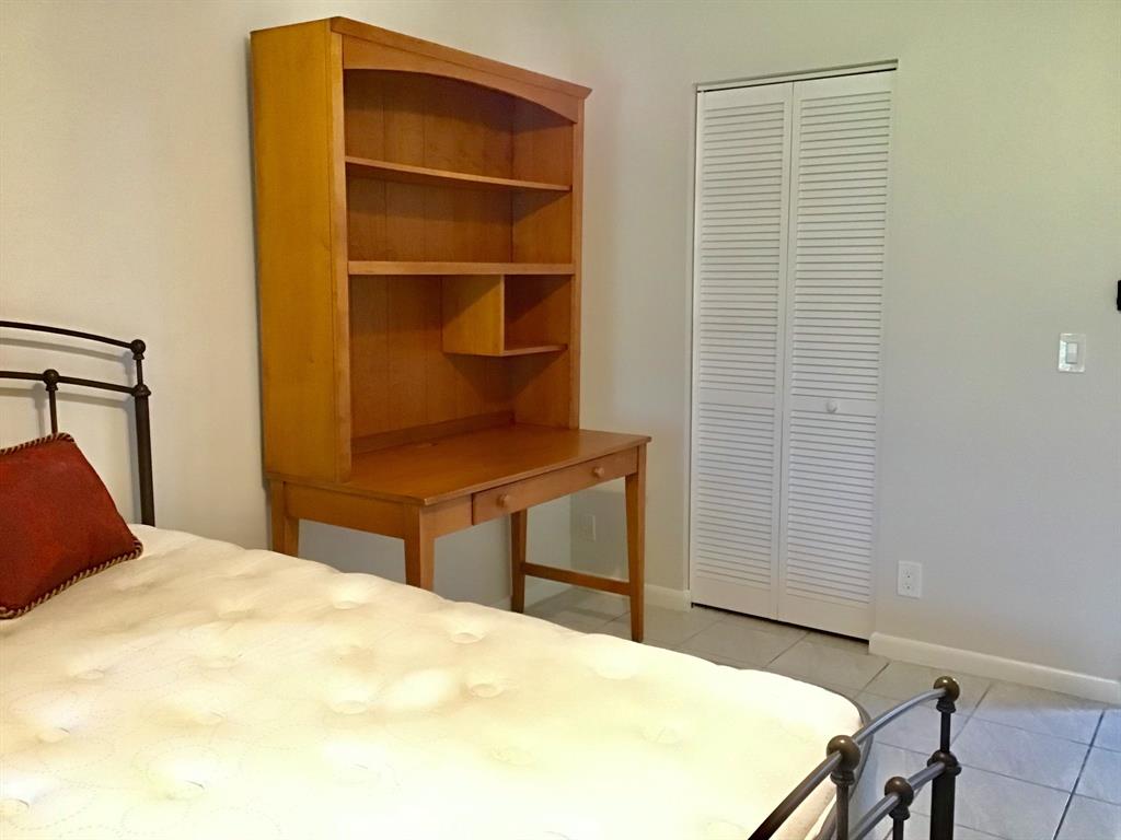 1004 Newcastle A, Unit 1004 Boca Raton, FL 33434 - Photo 23 of 39 a bedroom with a bed and a desk