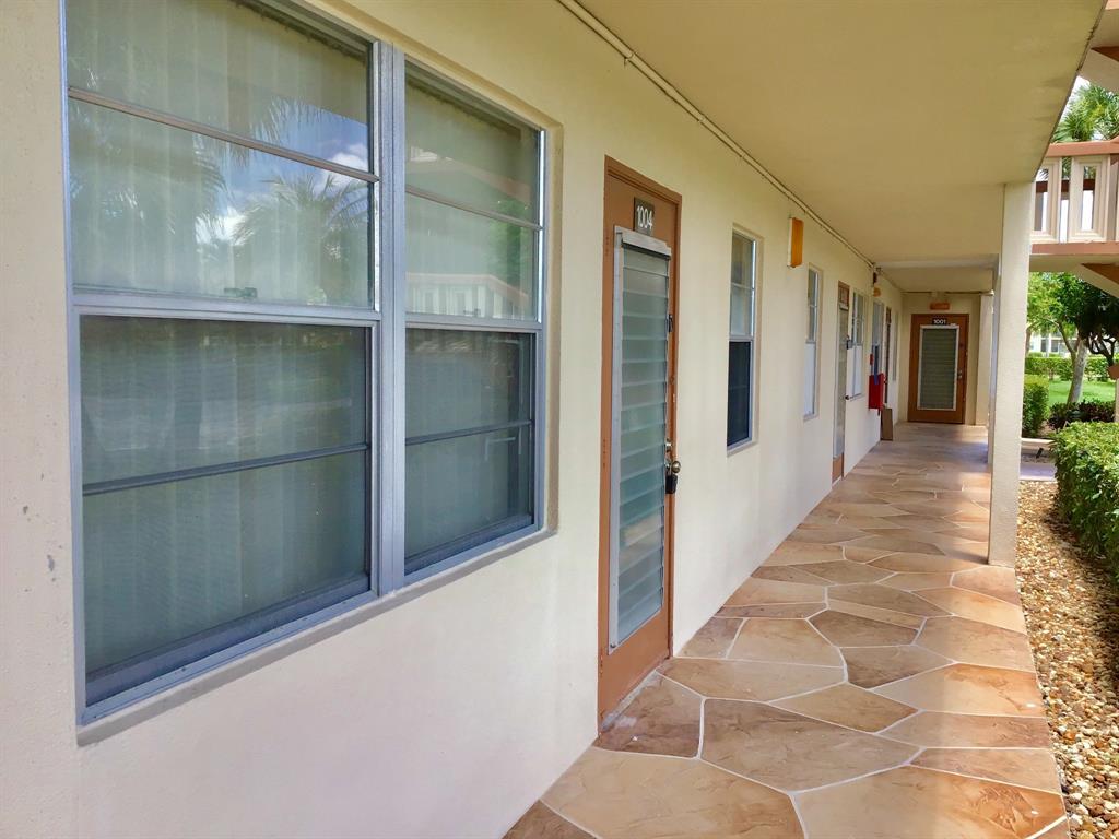 1004 Newcastle A, Unit 1004 Boca Raton, FL 33434 - Photo 33 of 39 a view of a hallway with wooden floor and windows