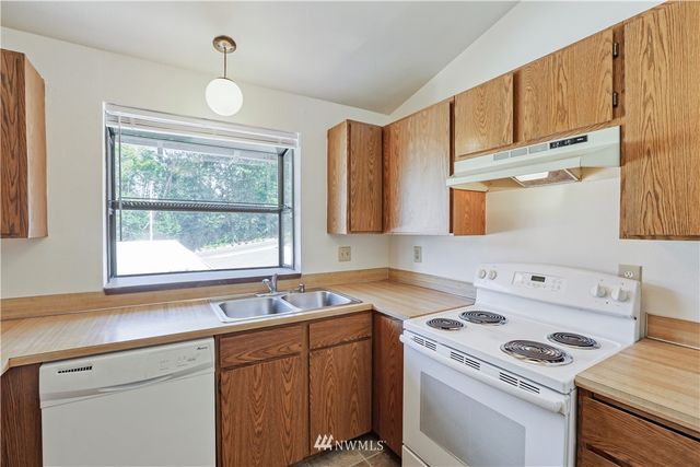 a kitchen with a stove a sink and a window
