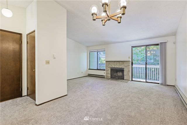 an empty room with windows and fireplace