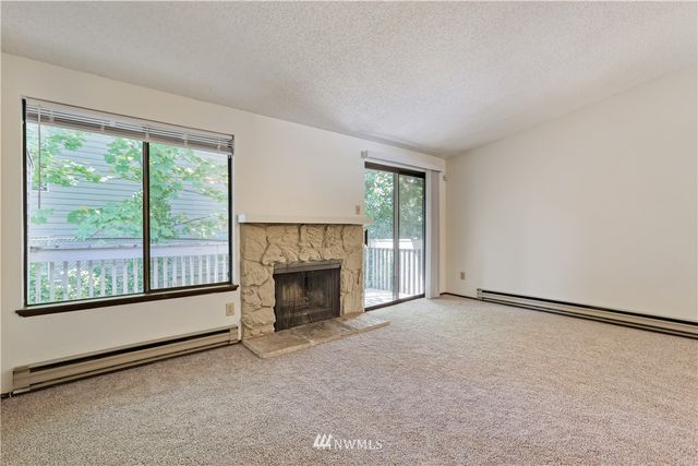 an empty room with fireplace and windows