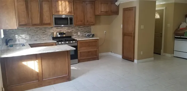 a kitchen with stainless steel appliances granite countertop a stove a sink and a refrigerator