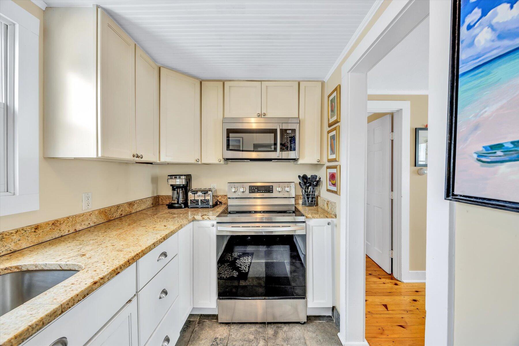 15 Cottage Street, Unit 2 Provincetown, MA 02657 - Photo 19 of 27 a kitchen with granite countertop a stove and a refrigerator