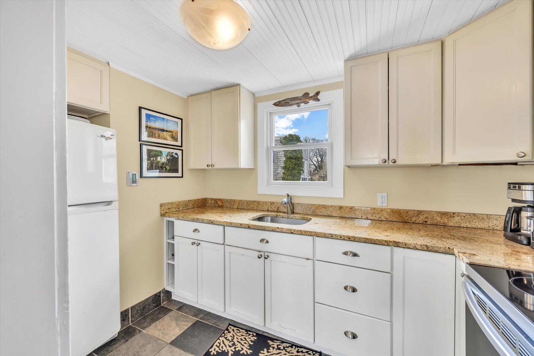 15 Cottage Street, Unit 2 Provincetown, MA 02657 - Photo 20 of 27 a kitchen with a sink cabinets and a window