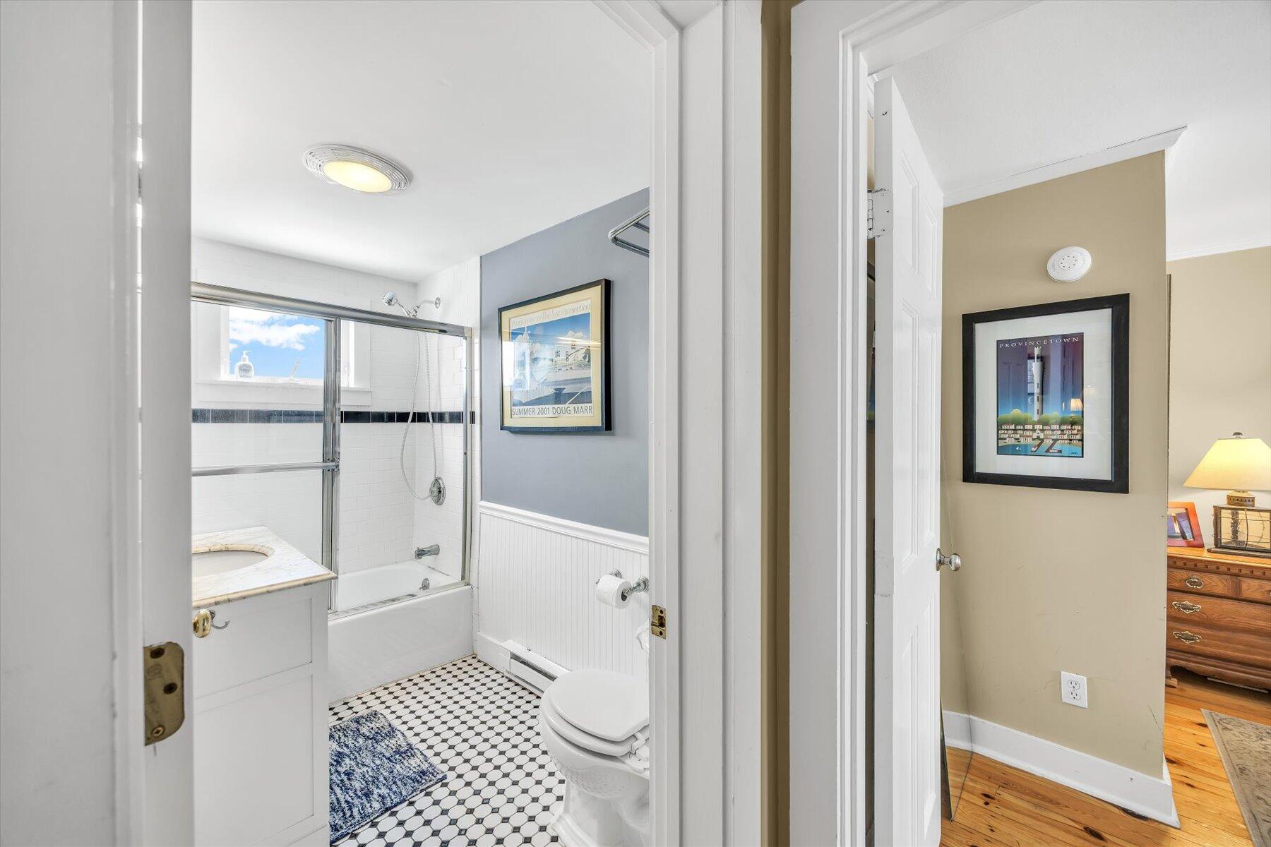 15 Cottage Street, Unit 2 Provincetown, MA 02657 - Photo 22 of 27 a bathroom with a glass door shower a sink and a toilet