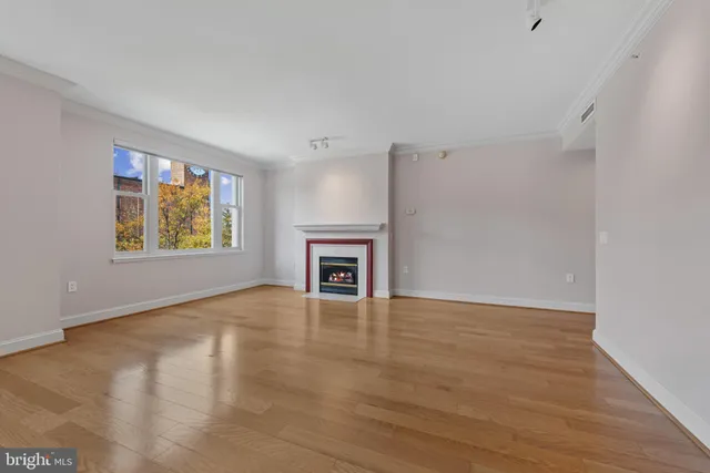 a view of an empty room with a window and fireplace