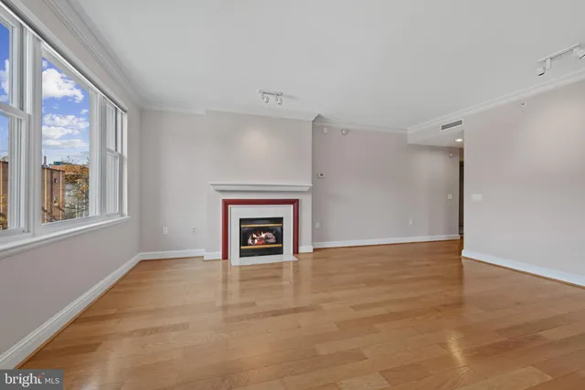 a view of empty room with wooden floor and fireplace
