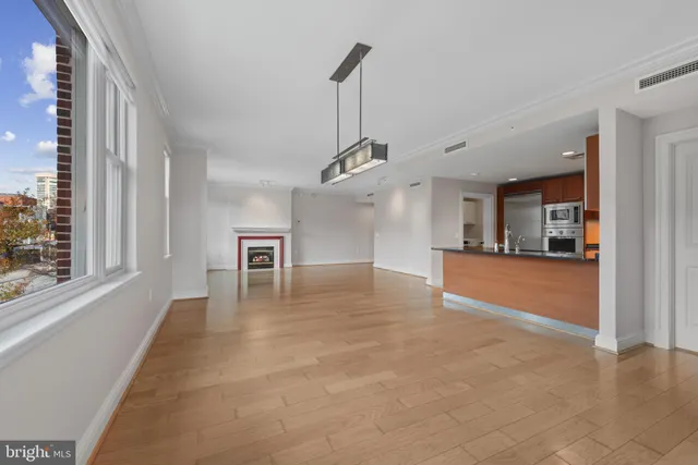 a view of empty room with wooden floor and windows