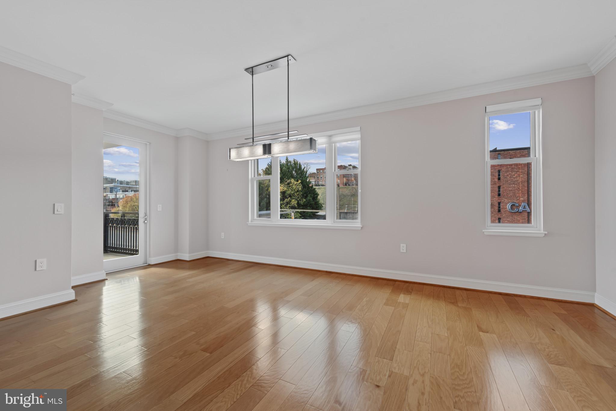 801 Key Highway, Unit 364 Baltimore, MD 21230 - Photo 22 of 54 an empty room with wooden floor chandelier and windows