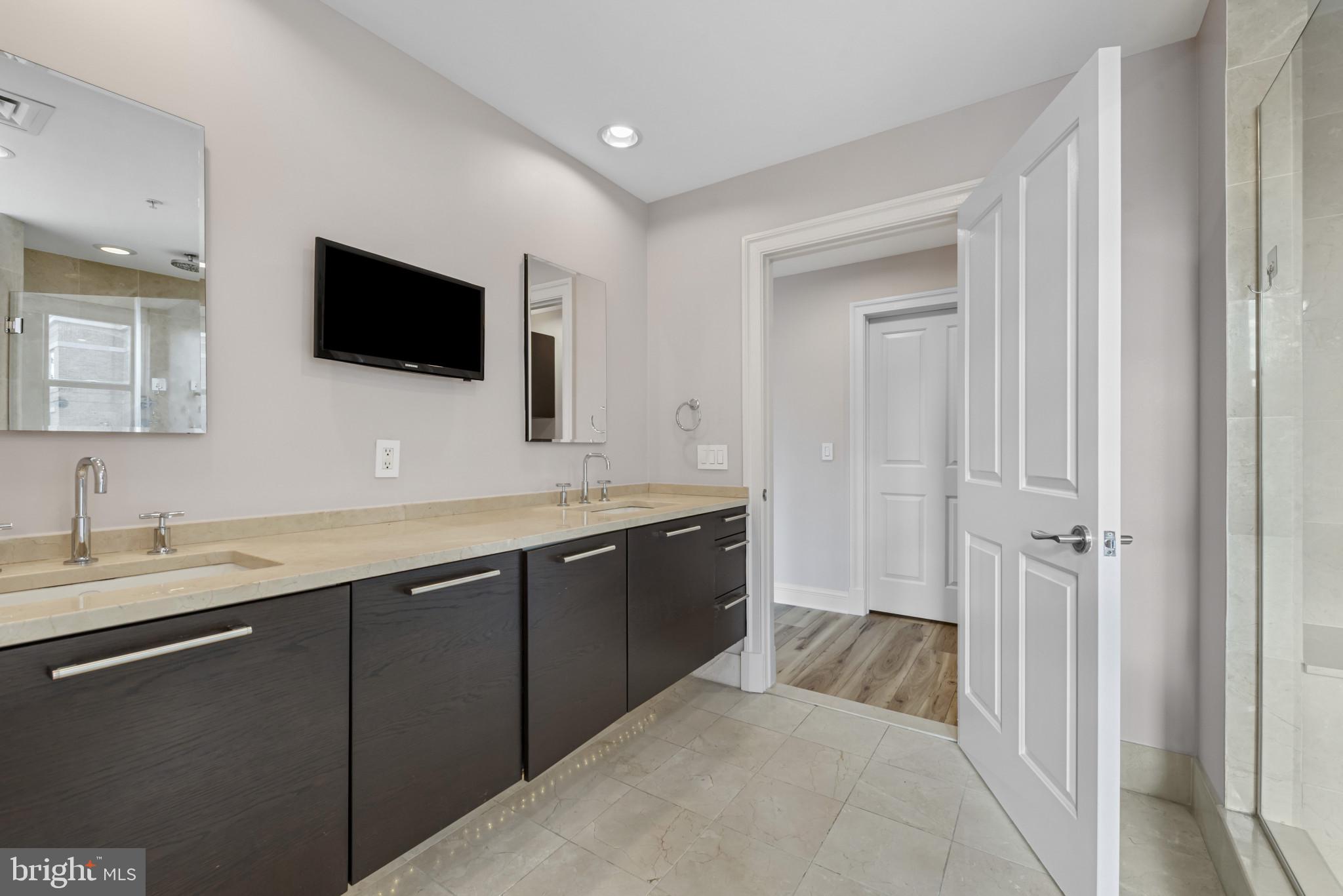 801 Key Highway, Unit 364 Baltimore, MD 21230 - Photo 33 of 54 a spacious bathroom with a granite countertop double vanity and a mirror