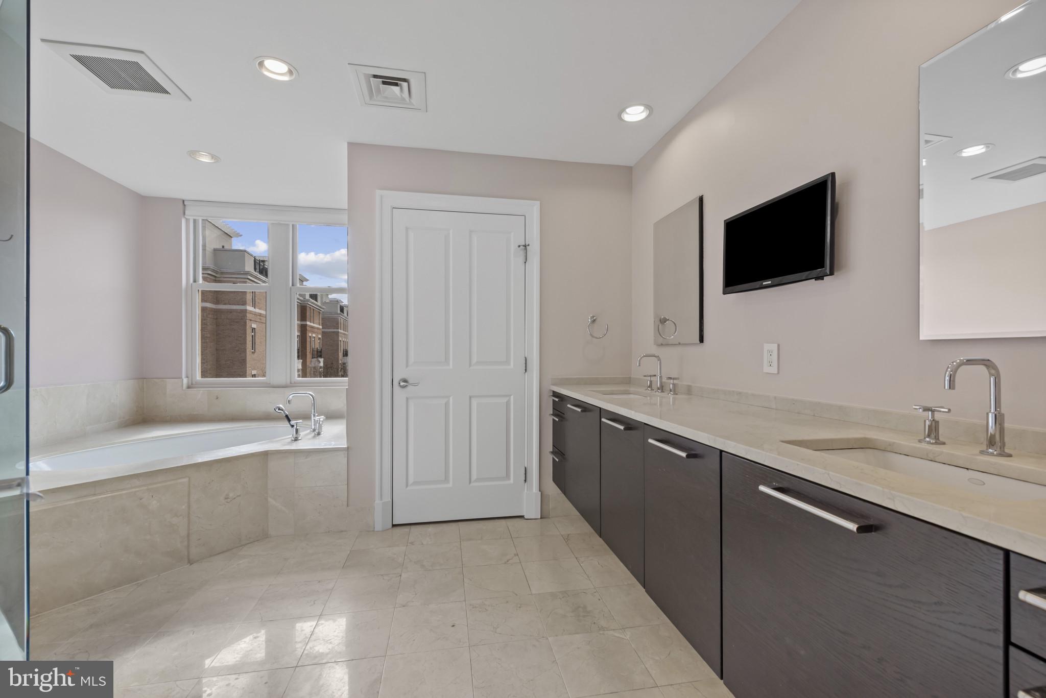 801 Key Highway, Unit 364 Baltimore, MD 21230 - Photo 36 of 54 a bathroom with a sink a large mirror and a bathtub