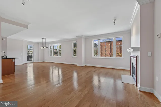 a view of an empty room with window and fire place
