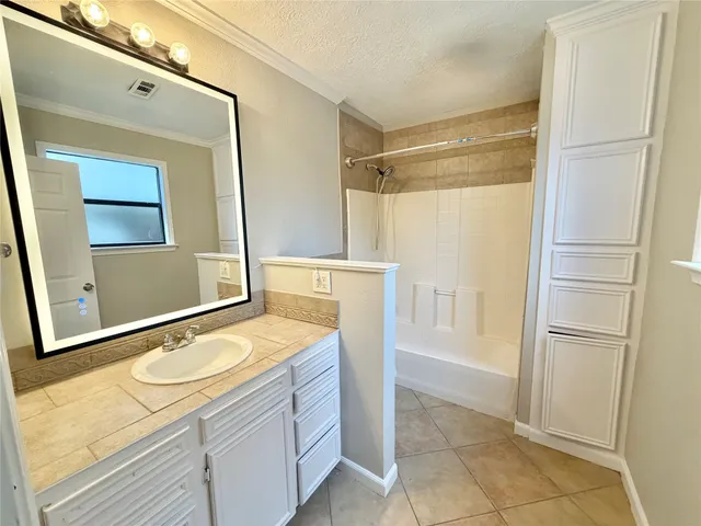a bathroom with a granite countertop sink mirror and shower